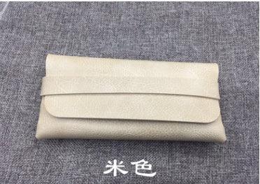 Beige textured leather clutch wallet on gray fabric background with Chinese characters below