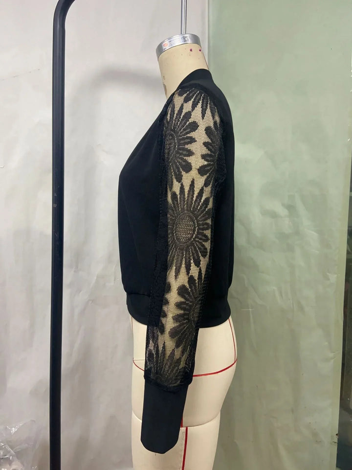 Black long-sleeve top with sheer floral lace sleeves on mannequin side view