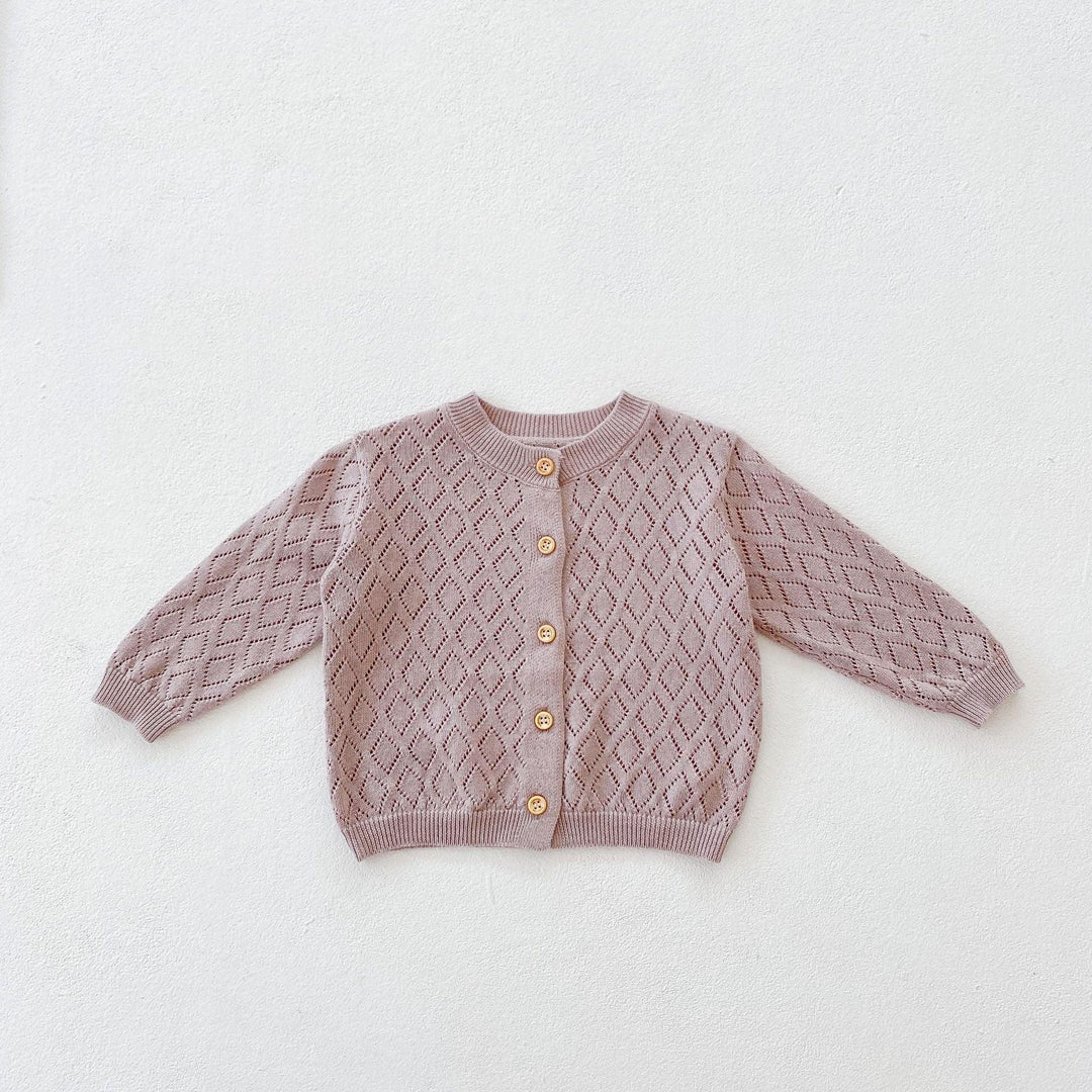 Pink knitted baby cardigan with diamond pattern and wooden buttons on white background