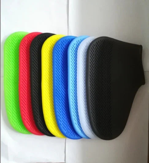 Colorful silicone bicycle handlebar grips in green, red, black, yellow, blue, white, and black lined up on white background