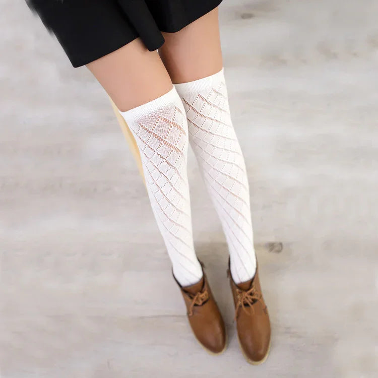 Woman wearing white patterned knee-high socks with brown ankle boots on a light floor