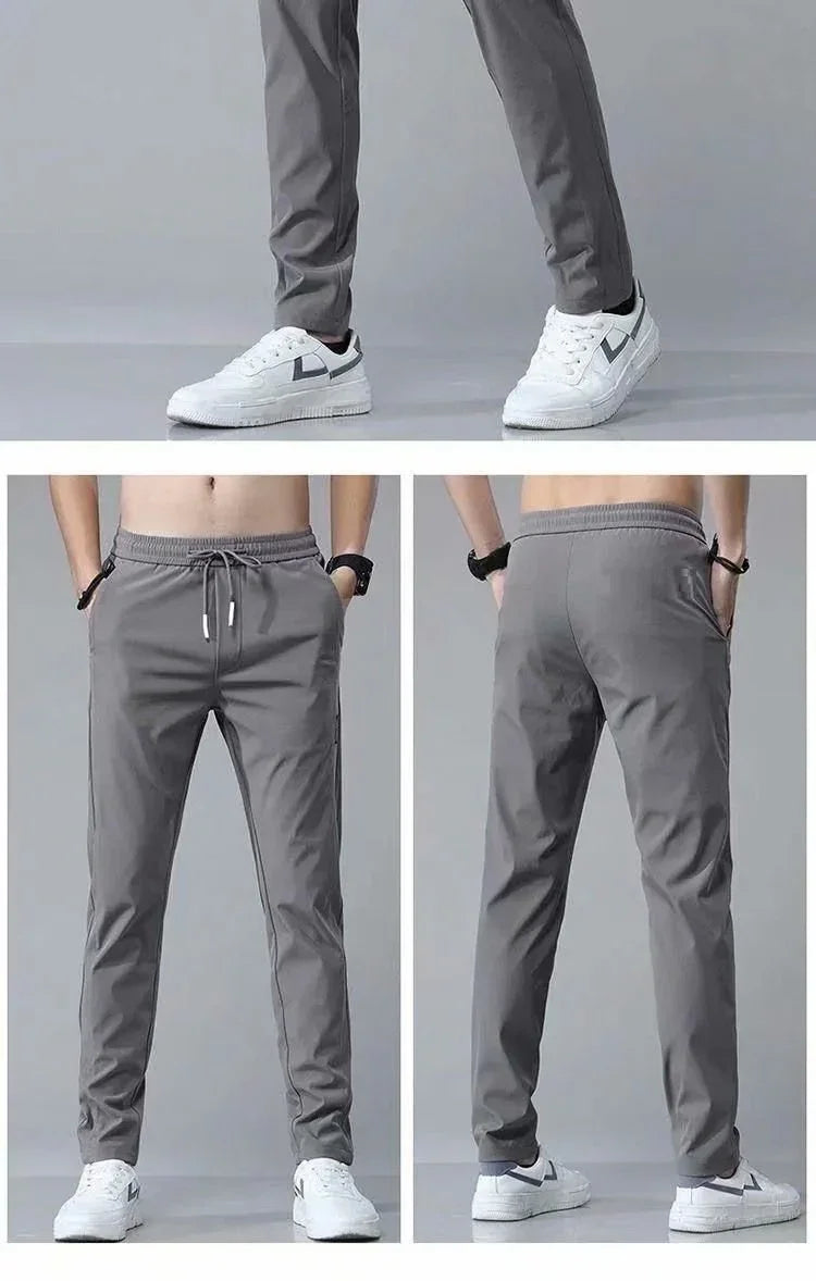 Men's gray slim fit jogger pants with drawstring and side pockets, paired with white sneakers