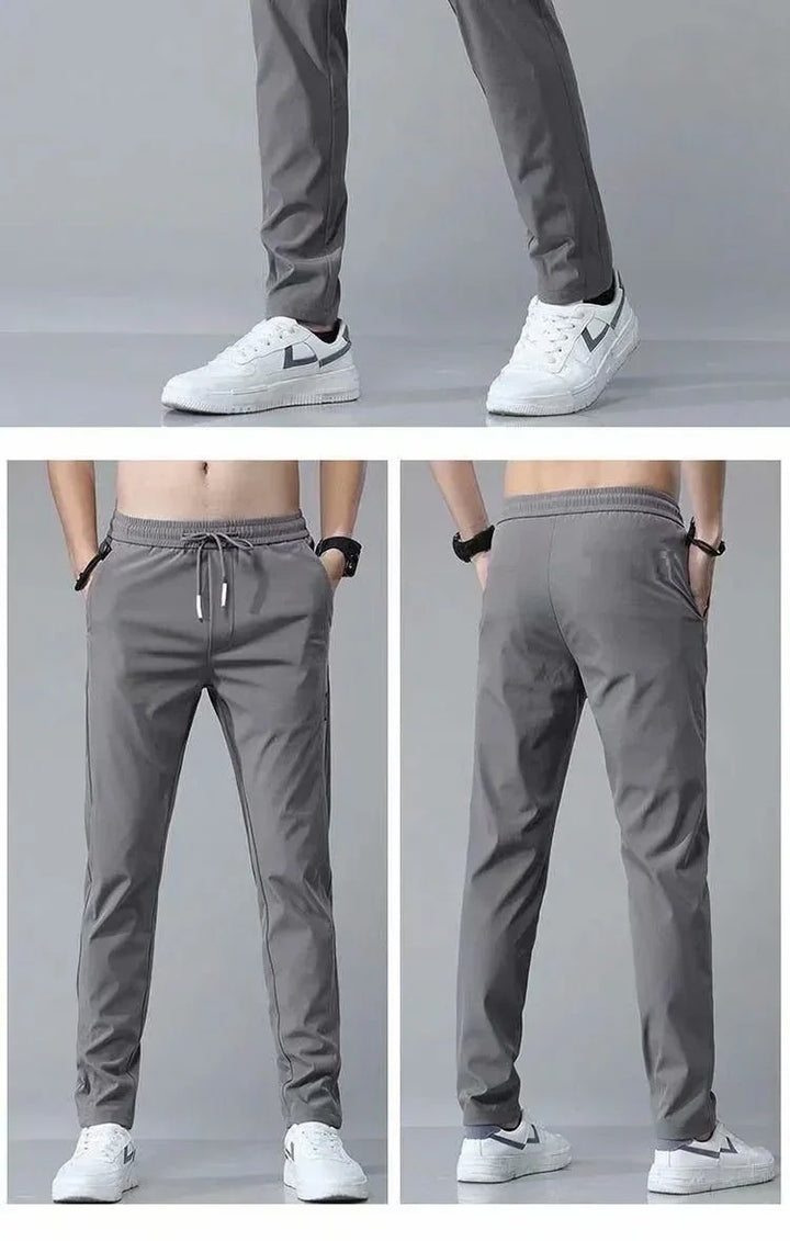 Men's gray slim fit jogger pants with drawstring and side pockets, paired with white sneakers
