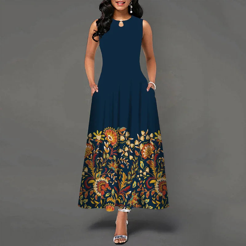 Woman wearing sleeveless navy blue maxi dress with colorful floral print at hem and pockets