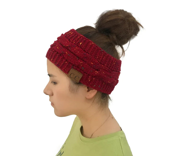 Side view of woman wearing burgundy knit headband with braided pattern and CC leather tag, hair in bun