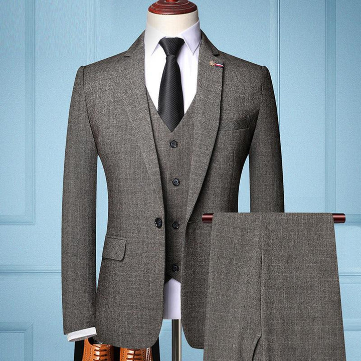 Gray three-piece men's suit with black tie on mannequin against blue paneled wall