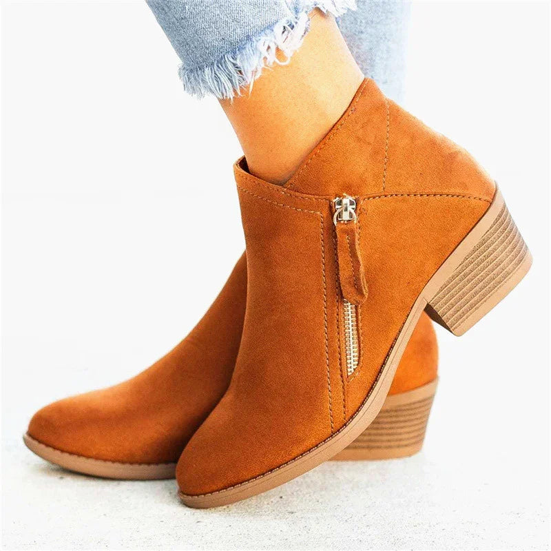 Women's tan suede ankle boots with side zipper and block heel, worn with frayed hem jeans