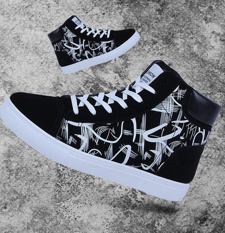 Black and white high-top sneakers with abstract graffiti design and white laces on concrete background