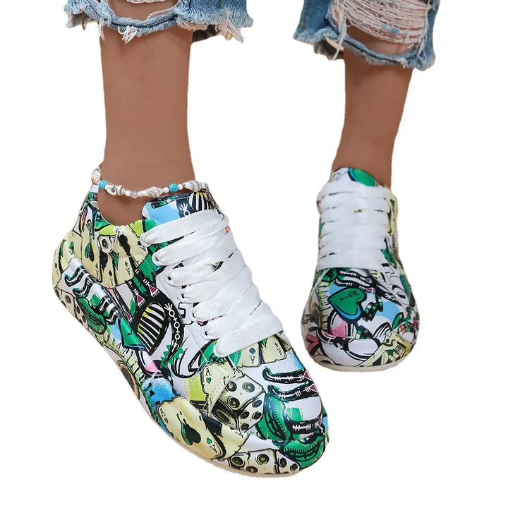Colorful graffiti print sneakers with white laces worn with ripped denim jeans and shell anklet
