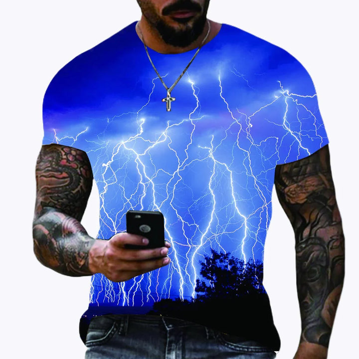 Man wearing blue T-shirt with lightning storm graphic, tattoos, and holding smartphone