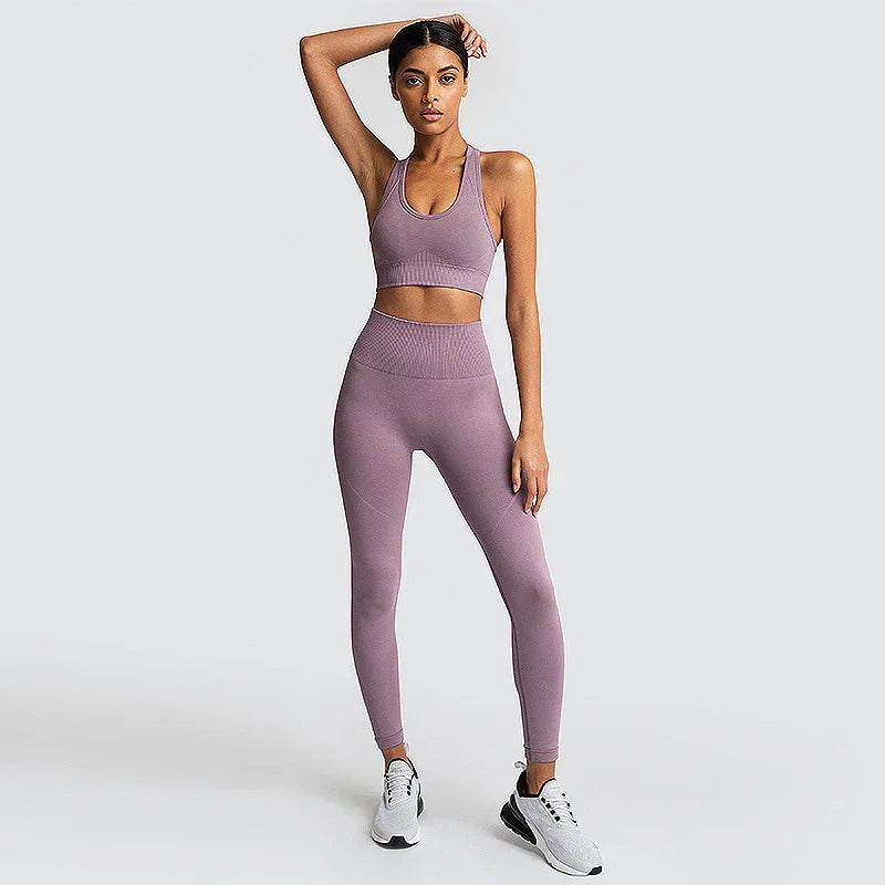 Woman in mauve seamless sports bra and leggings set, standing on white background