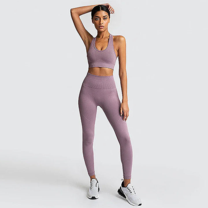 Woman in mauve seamless sports bra and leggings set, standing on white background