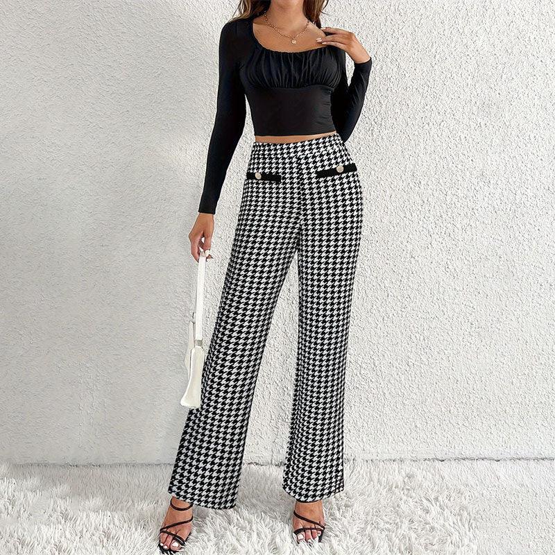 Woman wearing black ruched crop top and black-and-white houndstooth wide-leg pants with gold buttons