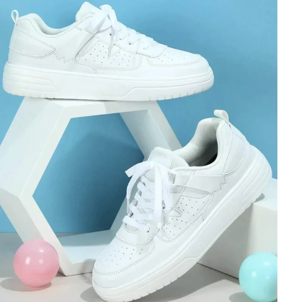 White casual sneakers displayed with geometric white stand and pastel blue and pink balls