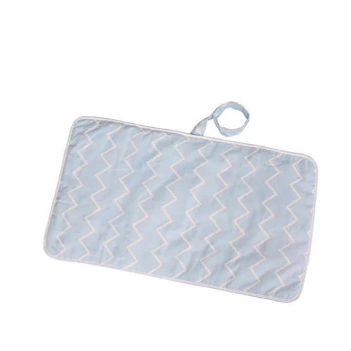 Light blue rectangular padded changing mat with white zigzag pattern and attached strap