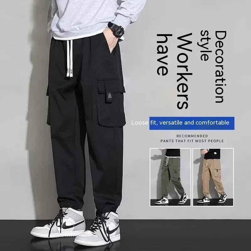 Man wearing black loose fit cargo pants with drawstrings and sneakers, showcasing versatile casual style