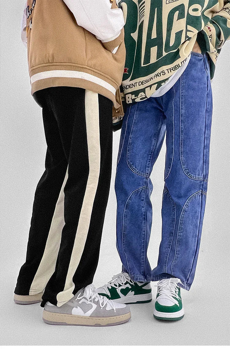 Two people wearing casual streetwear pants and sneakers against a plain background