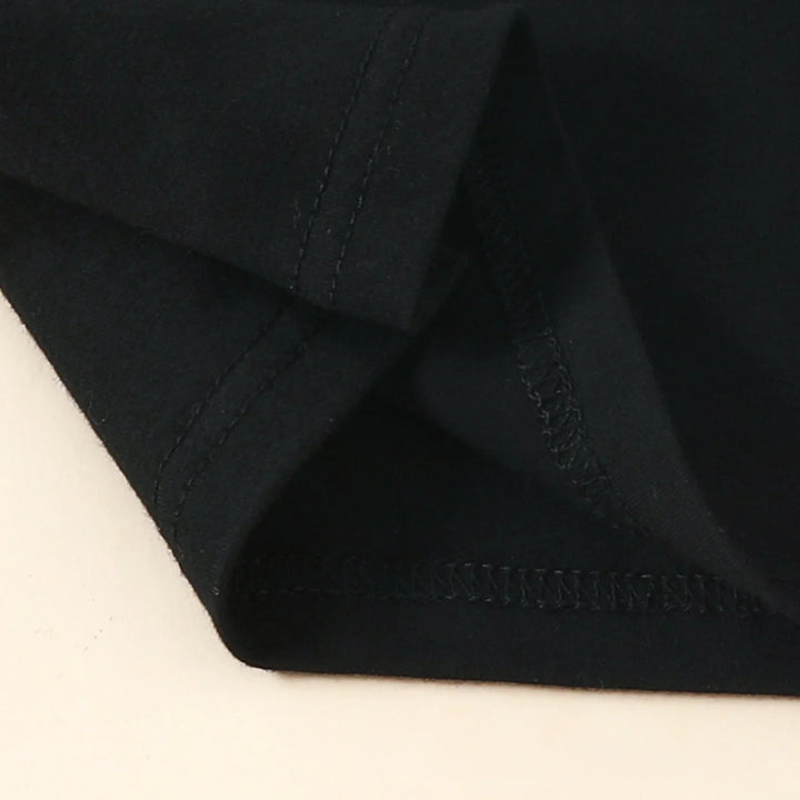 Close-up of black cotton fabric with detailed stitching on folded sleeve or hem