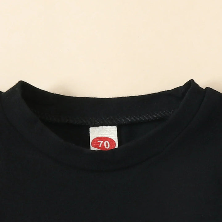 Close-up of black T-shirt neckline with size label marked 70 on beige background