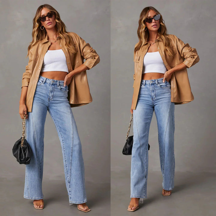 Woman in beige leather shirt jacket, white crop top, blue jeans, tan heels, sunglasses, holding black purse