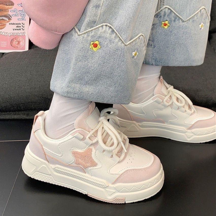 White and pink chunky sneakers with star detail worn with embroidered denim jeans and white socks