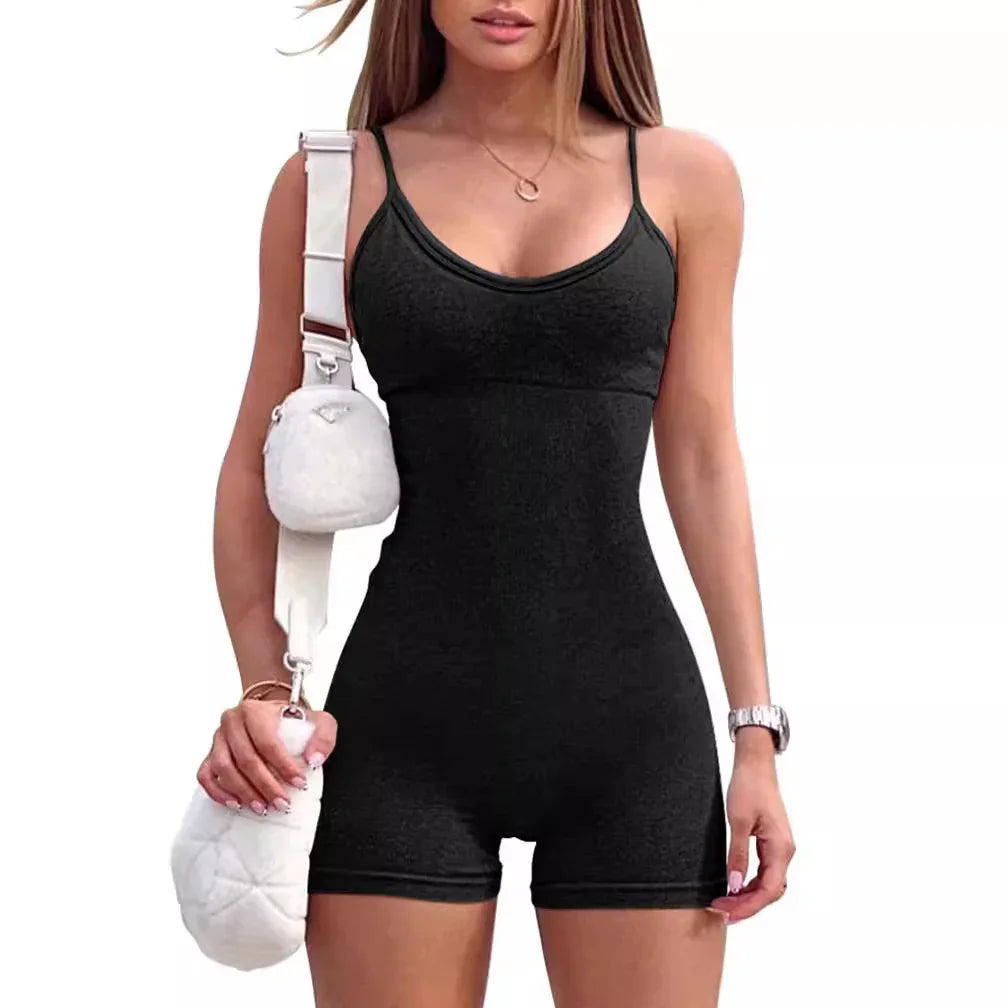 woman wearing black sleeveless romper with thin straps and carrying white shoulder bag