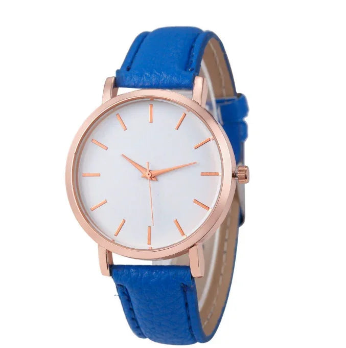 Minimalist wristwatch with rose gold case, white dial, and blue leather strap