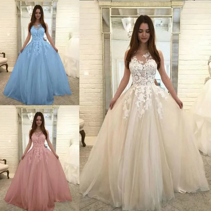 Woman modeling elegant ball gowns in white, blue, and pink with lace bodices in bridal boutique