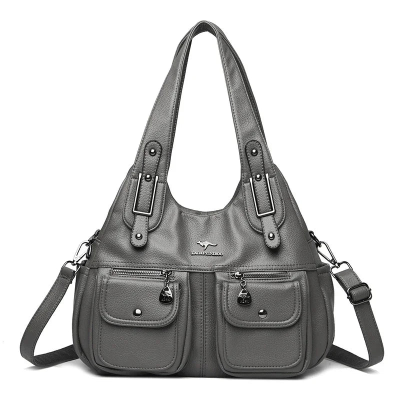 Gray leather tote handbag with dual front pockets, adjustable strap, and silver hardware