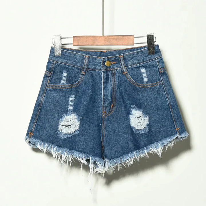 Blue distressed denim shorts with frayed hem hanging on wooden hanger