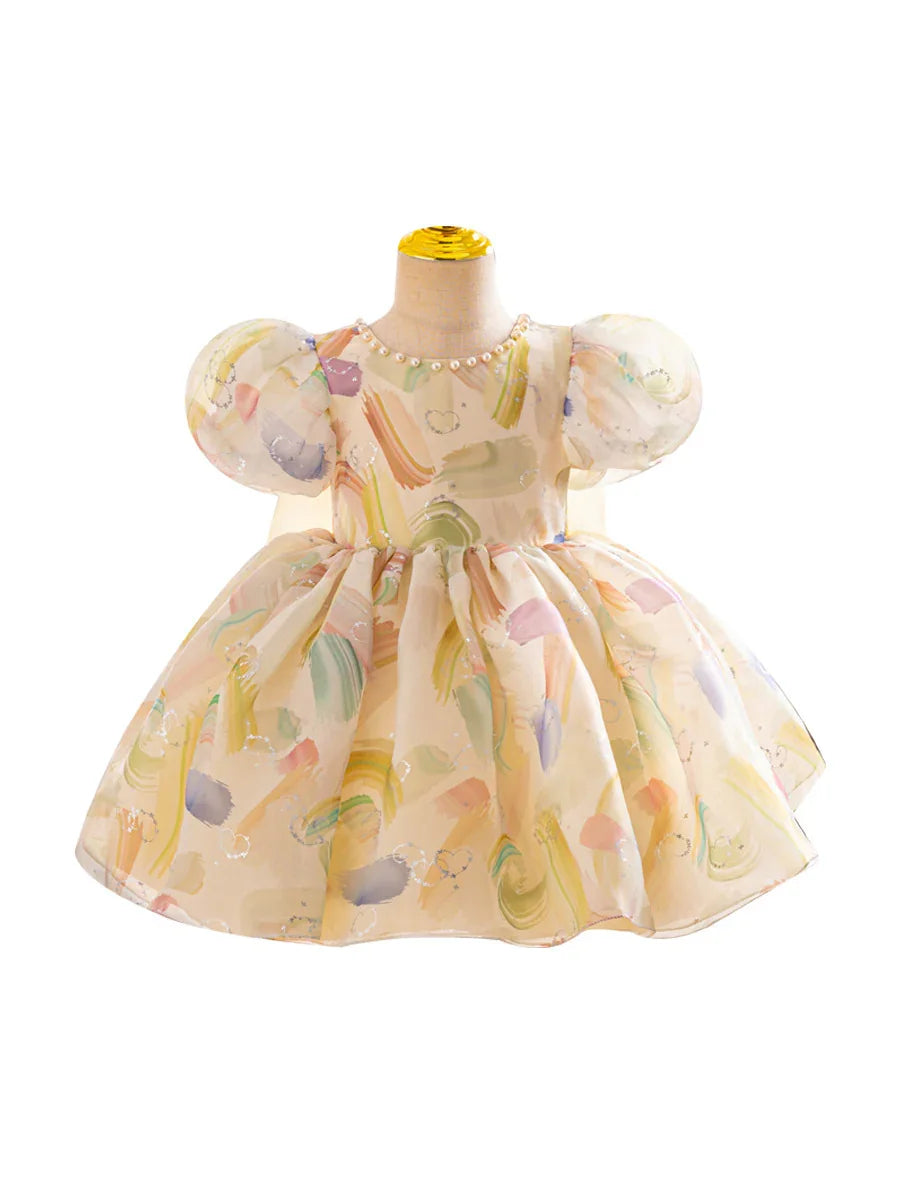 Pastel watercolor print baby dress with puff sleeves and pearl neckline on mannequin
