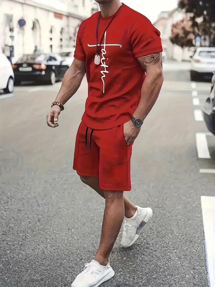 Man wearing red faith graphic t-shirt and matching shorts with white sneakers on city street