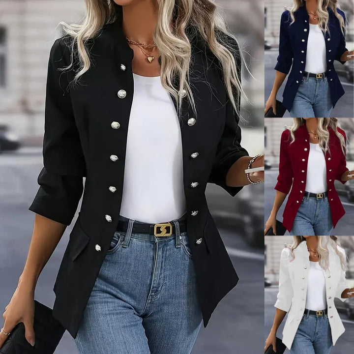 Woman wearing fashionable military-style blazer in black, navy, red, and white with silver buttons and jeans