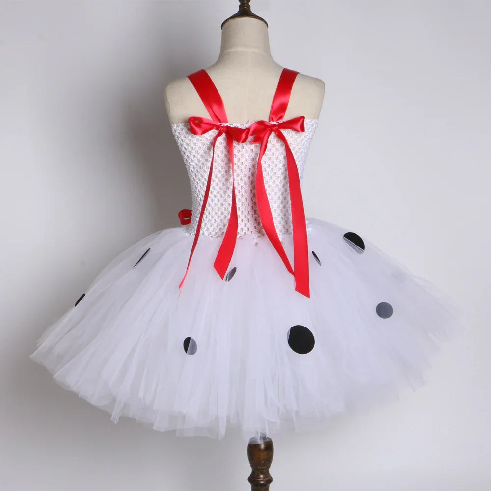 White tulle tutu dress with black polka dots and red satin ribbon straps on mannequin
