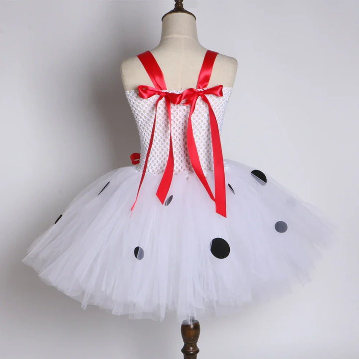 White tulle tutu dress with black polka dots and red satin ribbon straps on mannequin