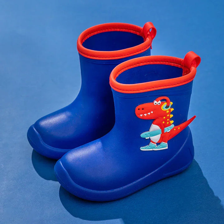 Blue children's rain boots with red trim and dinosaur skateboard design on dark blue background