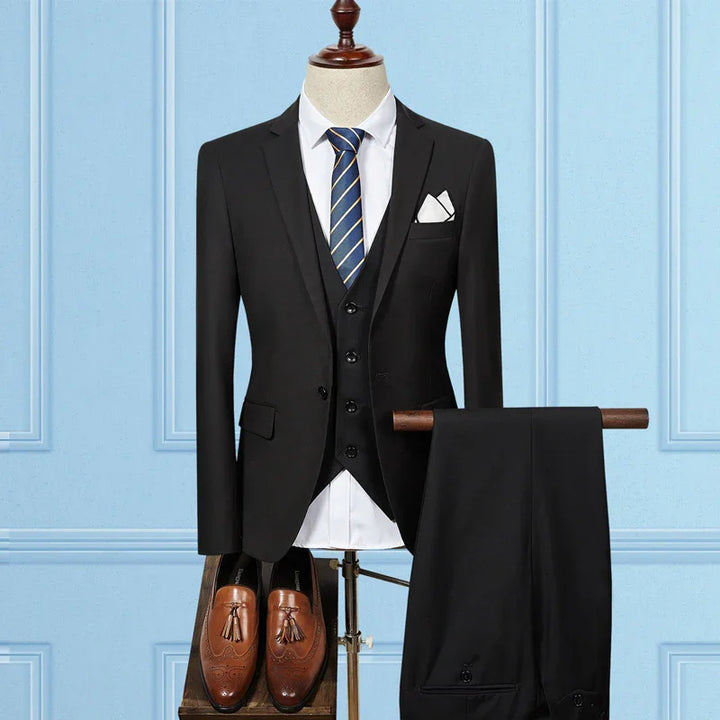 Black three-piece mens suit with white shirt, blue striped tie, brown tassel loafers on mannequin