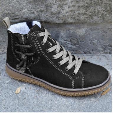 Black leather high-top casual shoe with beige laces, white inner lining, and textured sole on concrete