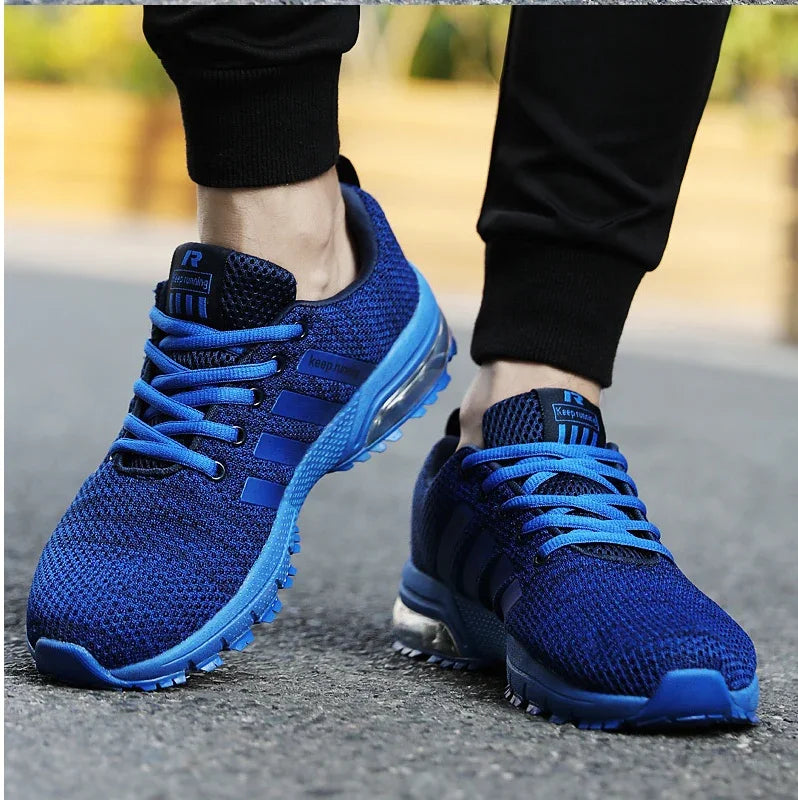 Close-up of blue knit running shoes with blue laces worn on pavement
