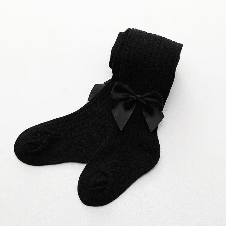 Pair of black ribbed knit socks with decorative black satin bows on a white background