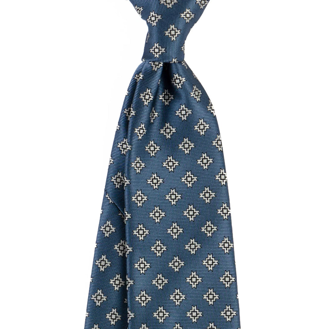 Blue silk tie with white and black geometric star pattern on white background