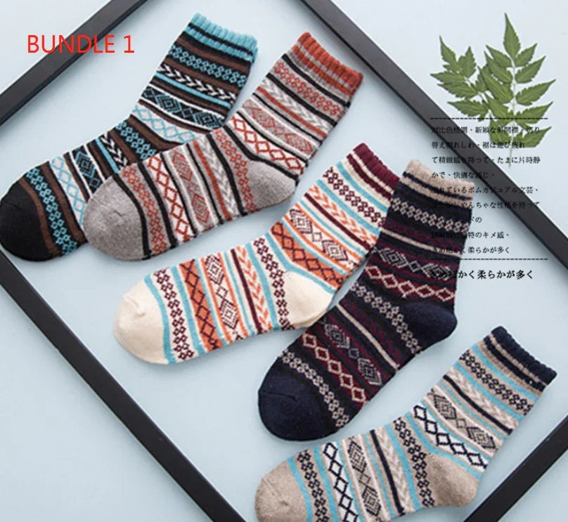 Bundle of five colorful patterned wool socks arranged in a black frame with green leaves