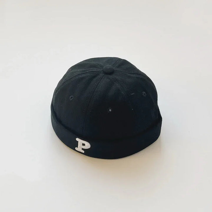 Black beanie cap with a white embroidered letter P on the front, displayed on plain white background
