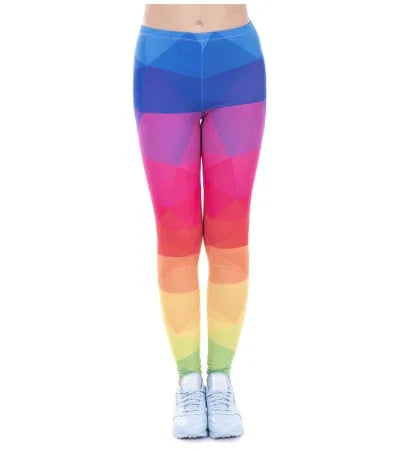 Woman wearing colorful geometric rainbow leggings and white sneakers on white background