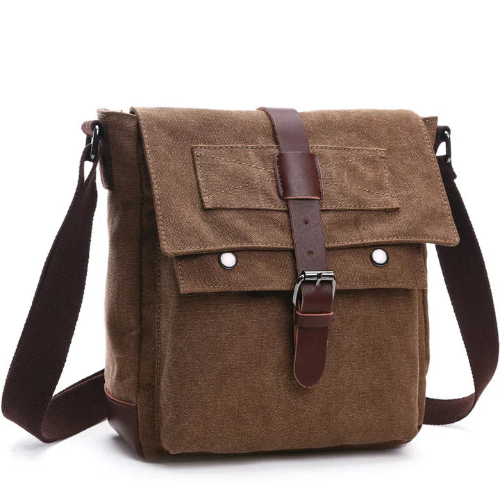 brown canvas crossbody messenger bag with leather buckle and adjustable strap on white background