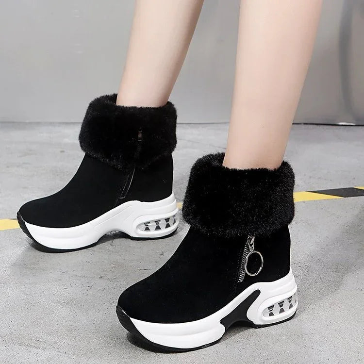 Black fur cuff ankle boots with white platform soles and side zipper on concrete floor