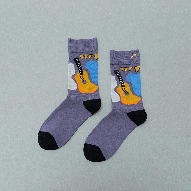 Purple socks with black toes and heels featuring an orange guitar and blue and white abstract design