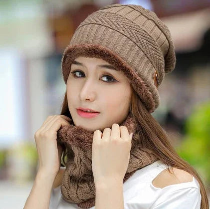 Young woman wearing a brown knit hat and matching fur-lined neck warmer outdoors