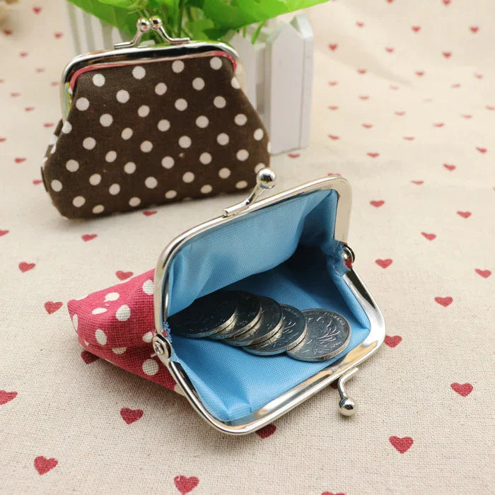 Polka dot fabric coin purses with metal clasps, one open showing blue lining and coins