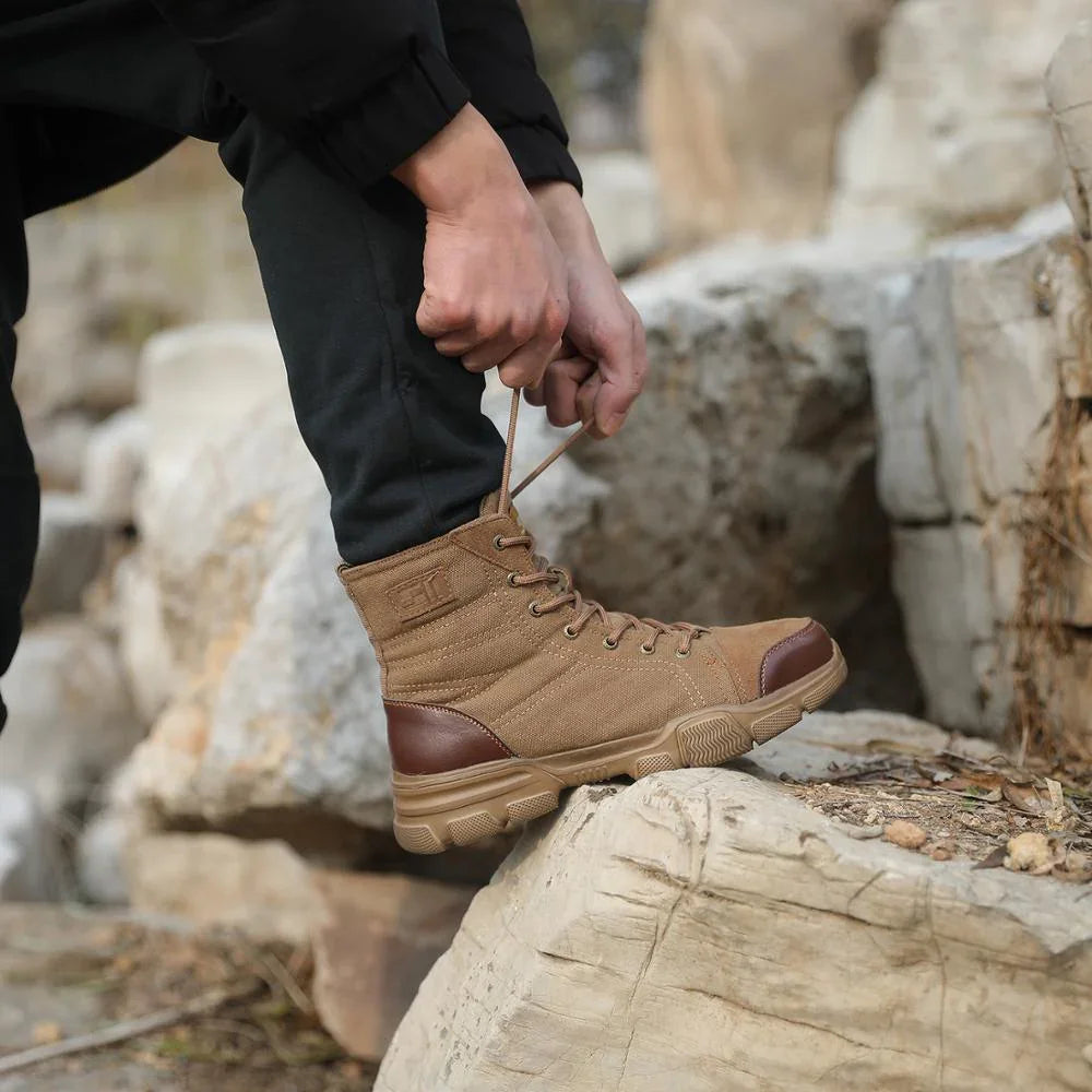 Person tying brown canvas and leather hiking boots on rocky terrain outdoors